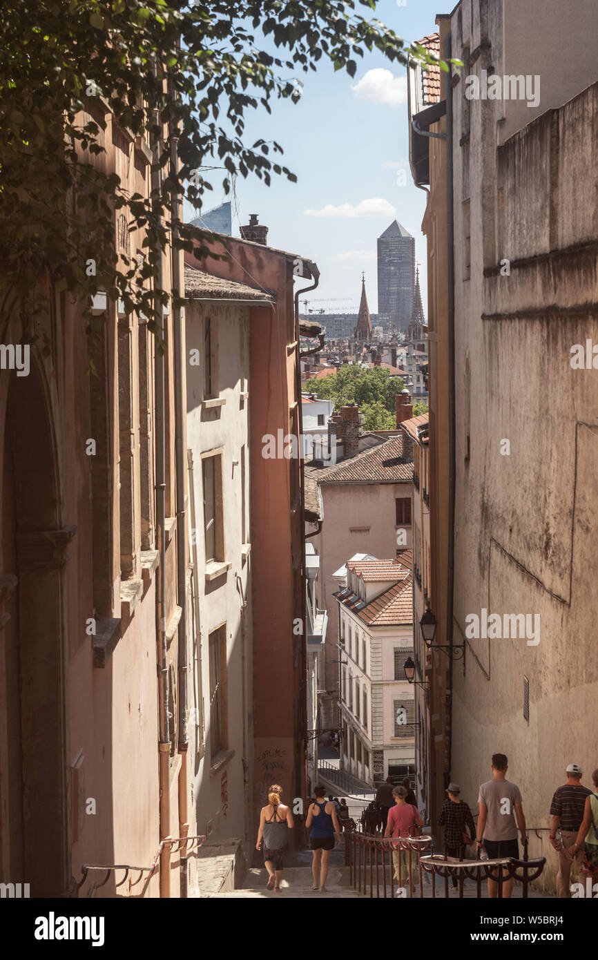 Lione, Francia - 14 luglio 2019: Montee des Carmes Dechausses passi di Fourviére, atipica strada stretta del Vieux Lyon (vecchia Lione) con il grattacielo Foto Stock