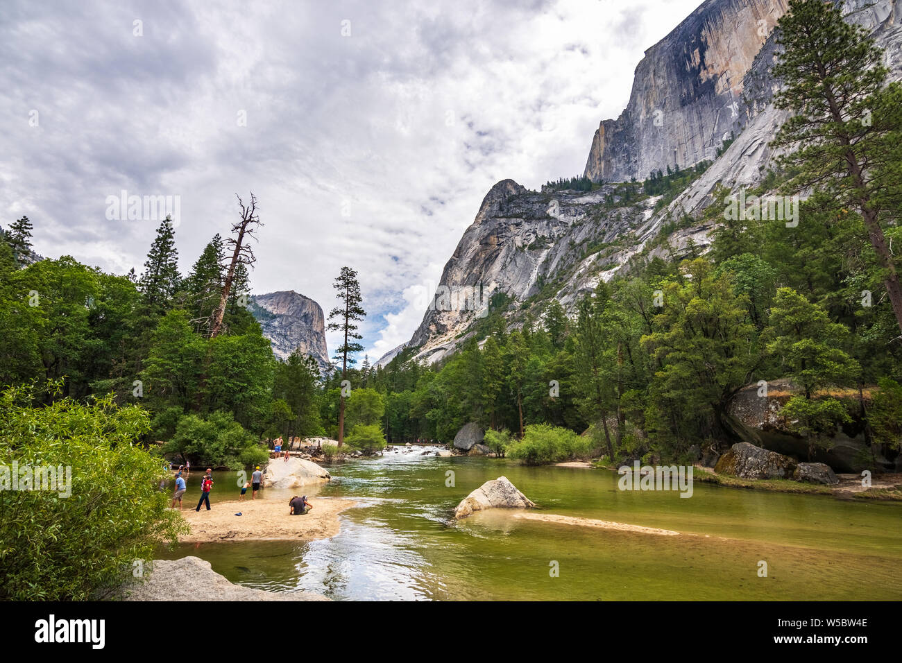 Giugno 28, 2019 il Parco Nazionale di Yosemite / CA / STATI UNITI D'AMERICA - Persone relax e divertimento sulle rive del lago a specchio, lungo Tenaya Creek; mezza cupola visibile Foto Stock