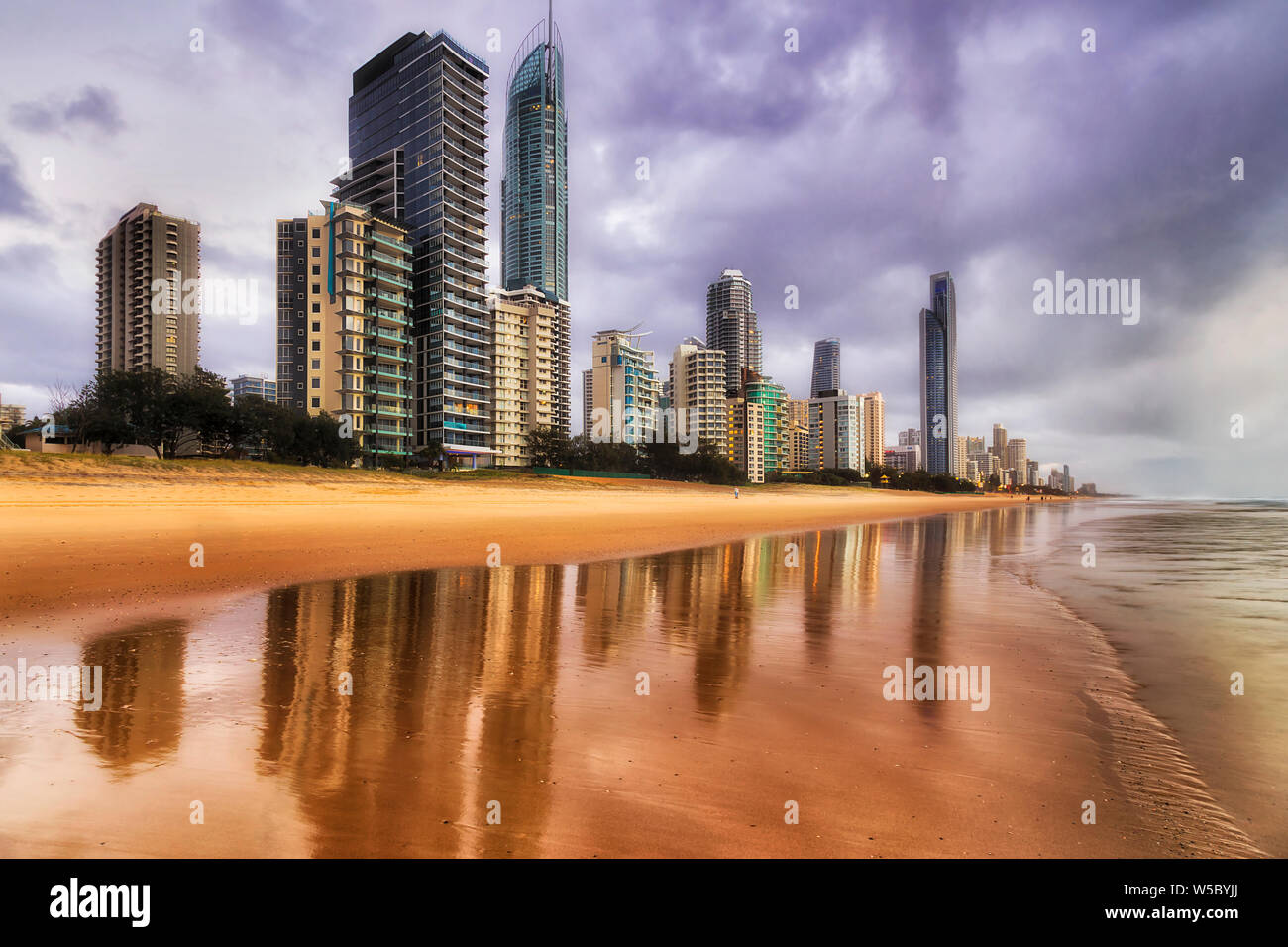 Pulire la sabbia dorata di Pacific Ocean Beach lungo Surfers paradise su Australian Gold Coast all'alba in tempo nuvoloso con onde sfocata. Foto Stock