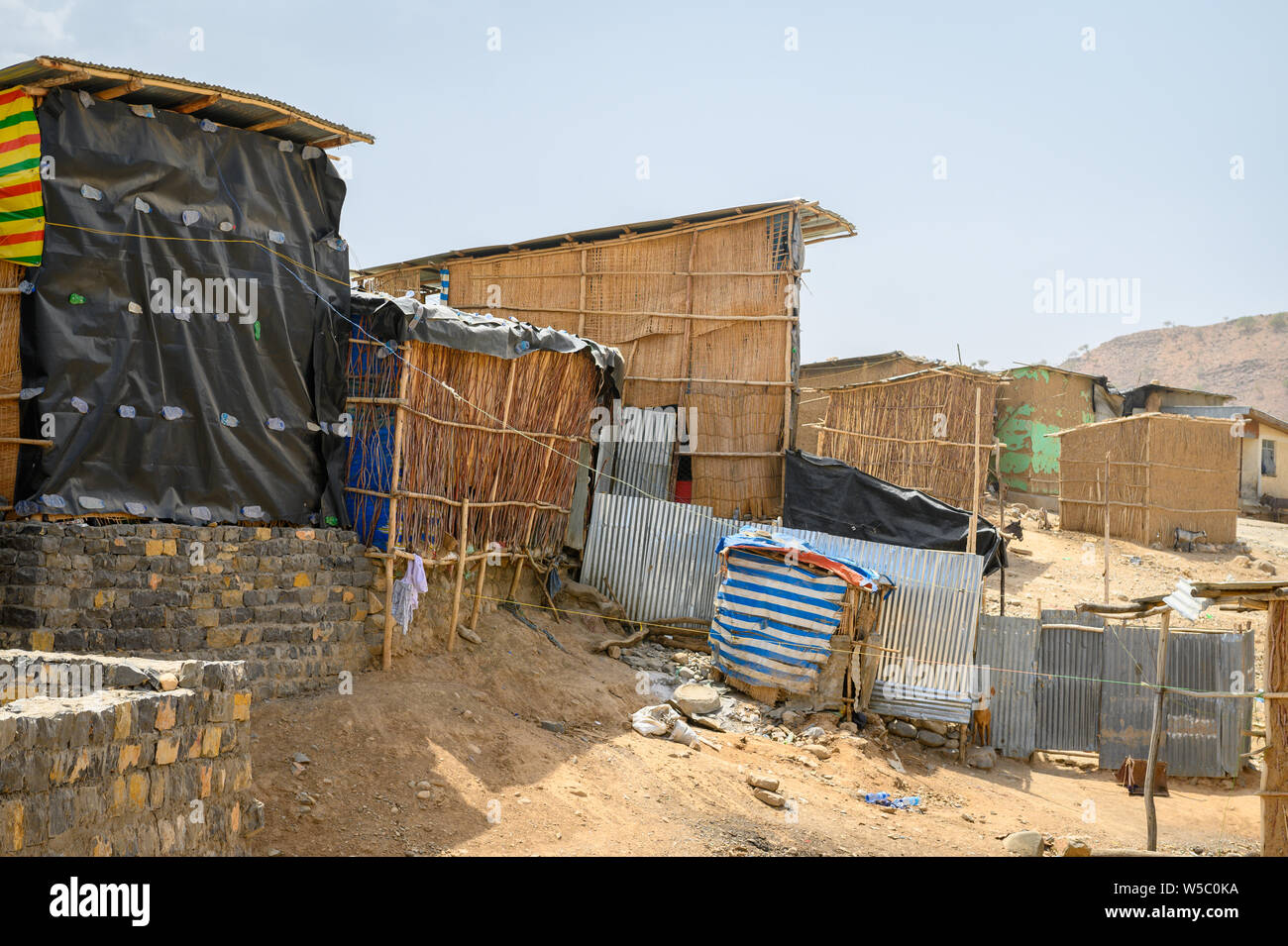 Un gruppo di case di fortuna costruiti da una varietà di materiali raccolti, Danakil depressione , Etiopia Foto Stock