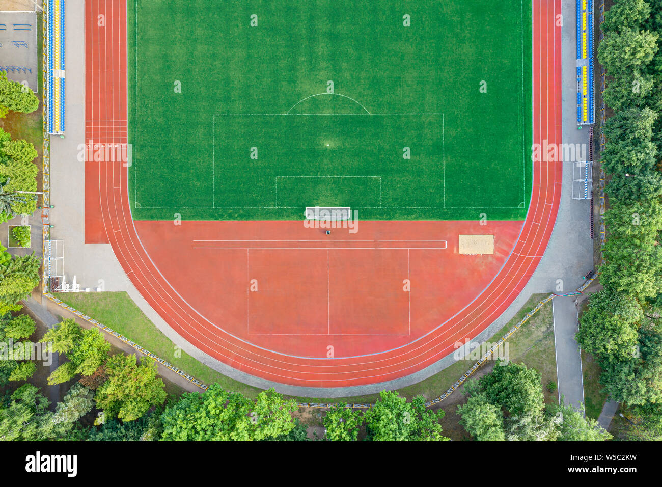 Vista aerea del vuoto artificiale verde di un campo da calcio con pista per la corsa Foto Stock