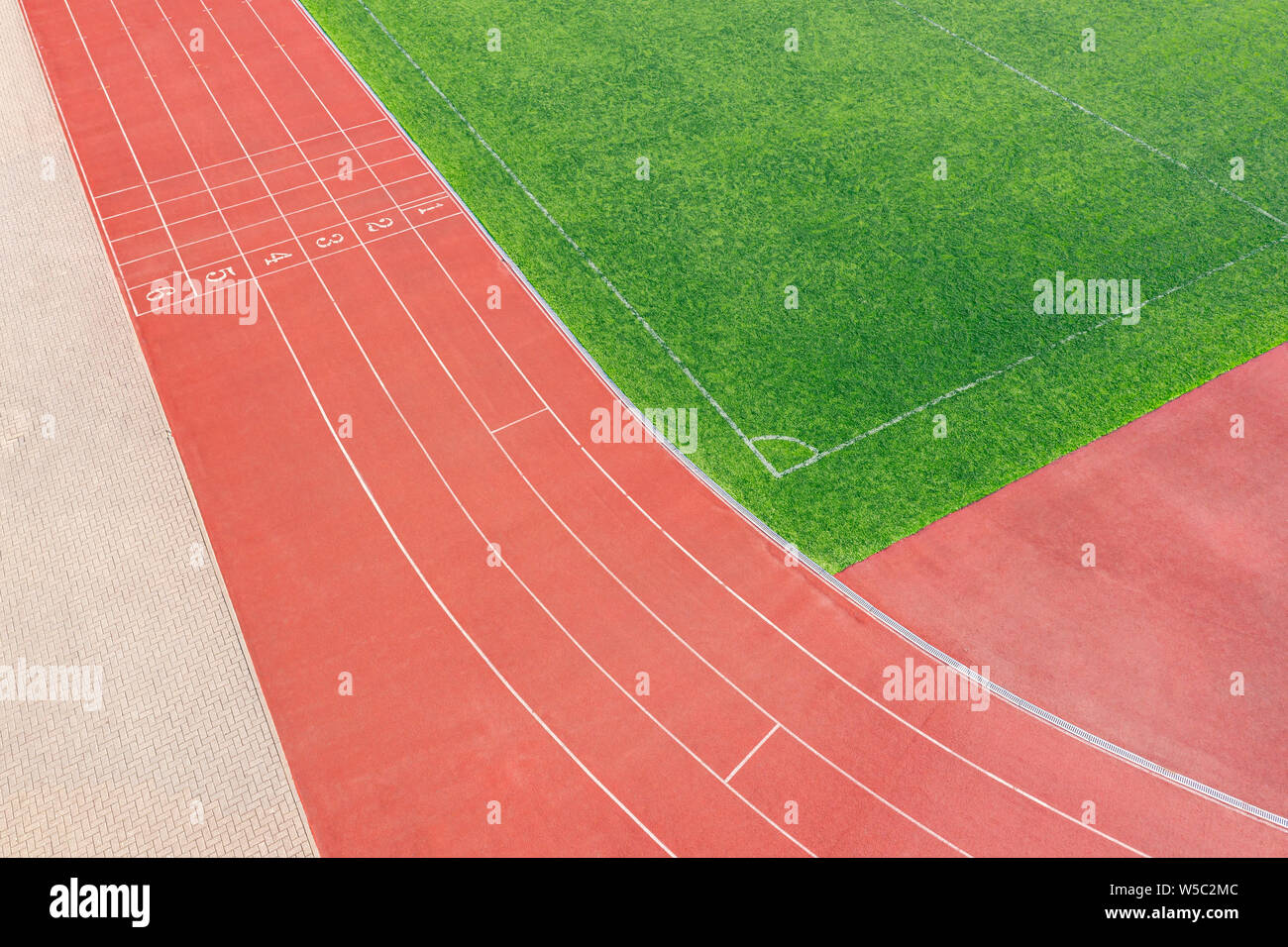 Traccia di cenere in stadio di atletica e campo da calcio con artificiali erba verde Foto Stock