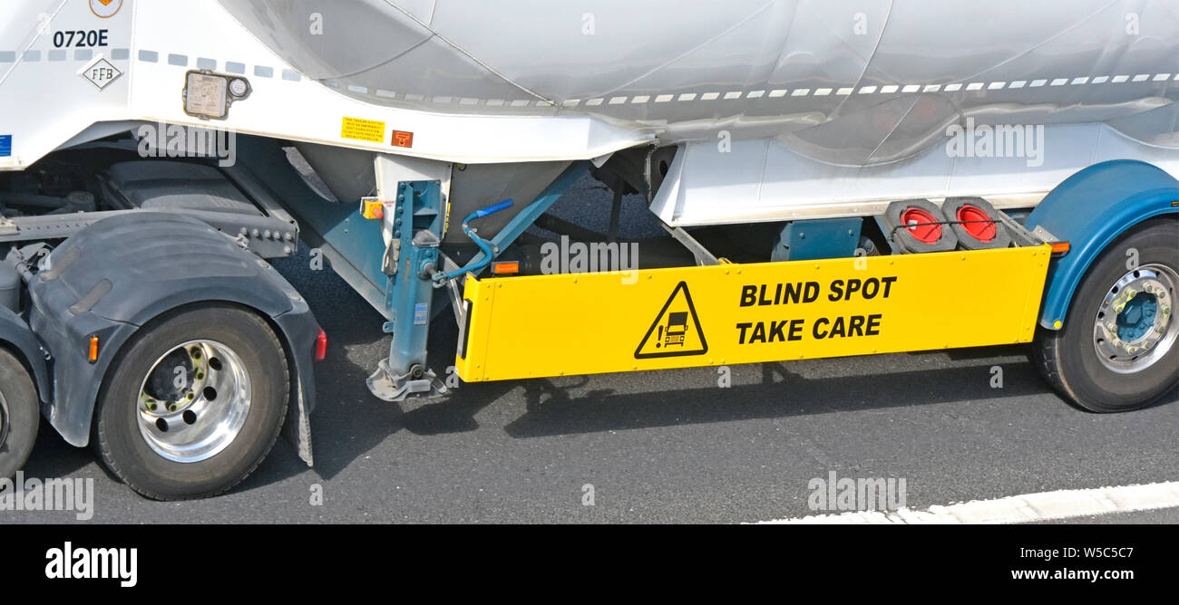 Giallo blind spot & prendersi cura di avvertimento sul pannello di protezione montato tra le ruote sul lato di hgv autocarro autocarro cisterna rimorchio per UK vulnerabili di utenti della strada Foto Stock