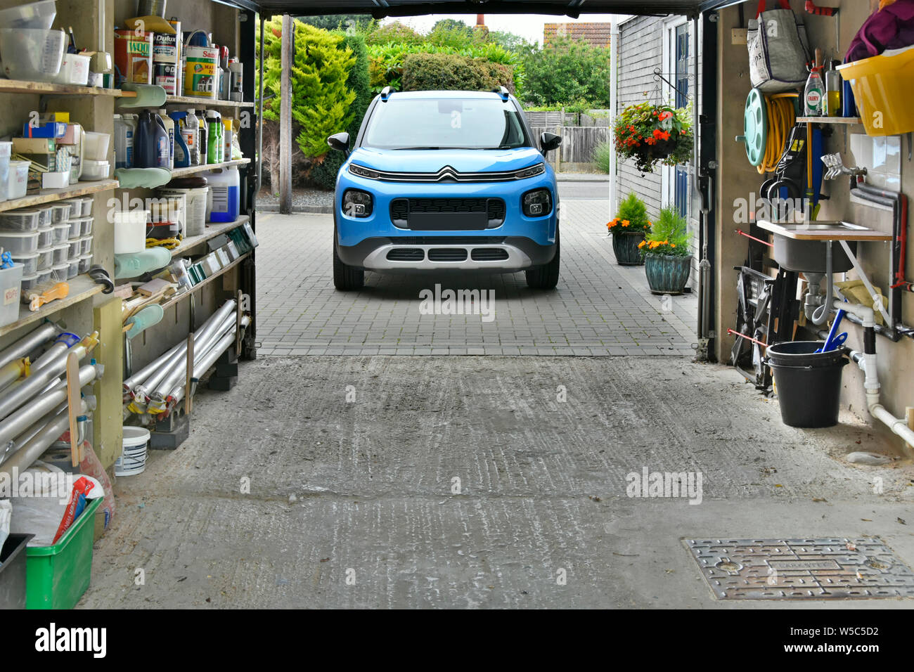 Aircross Citroen C3 SUV & vialetto garage attaccata alla casa usata per auto & deposito masserizie di casa paraphernalia tools & garden chemicals England Regno Unito Foto Stock