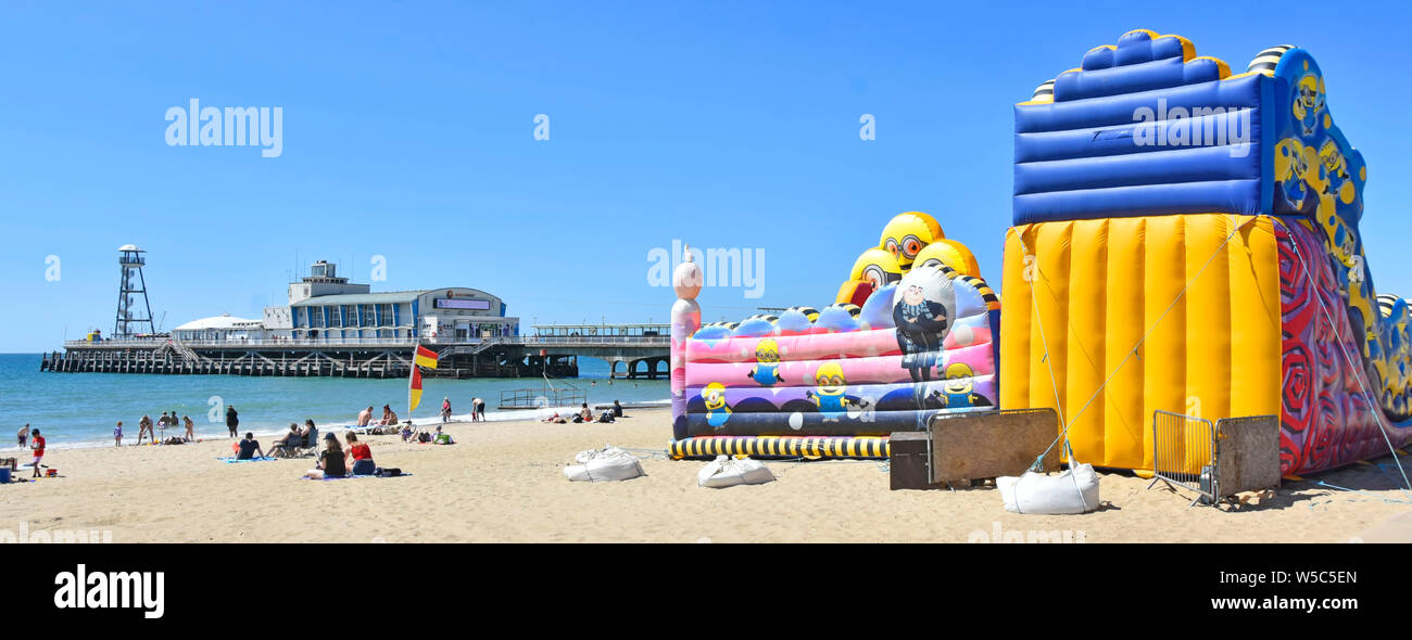 Gommoni bouncy castello & slide ormeggiato a sacchi riempiti con sabbia impedisce la salute & sicurezza danni da vento fatalità mare spiaggia di Bournemouth Dorset Regno Unito Foto Stock