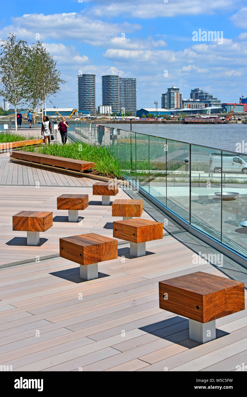 Sedili di legno su 'la marea' ponti un parco lineare links Fiume Tamigi riverside con alta linea passeggiate intorno a Greenwich Peninsula South London Inghilterra England Regno Unito Foto Stock