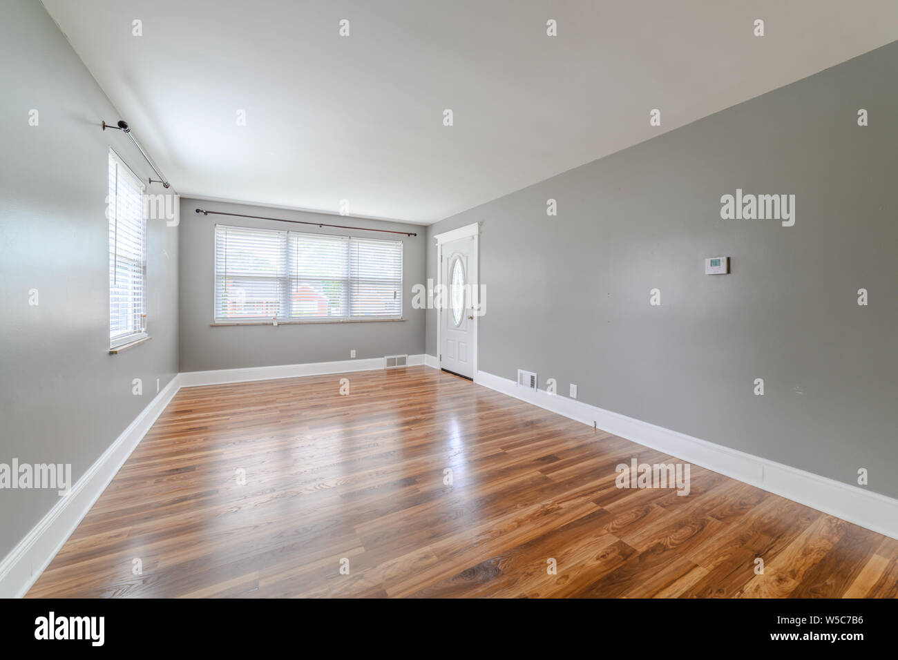 Un vuoto non decorato soggiorno con pavimenti in legno. Foto Stock