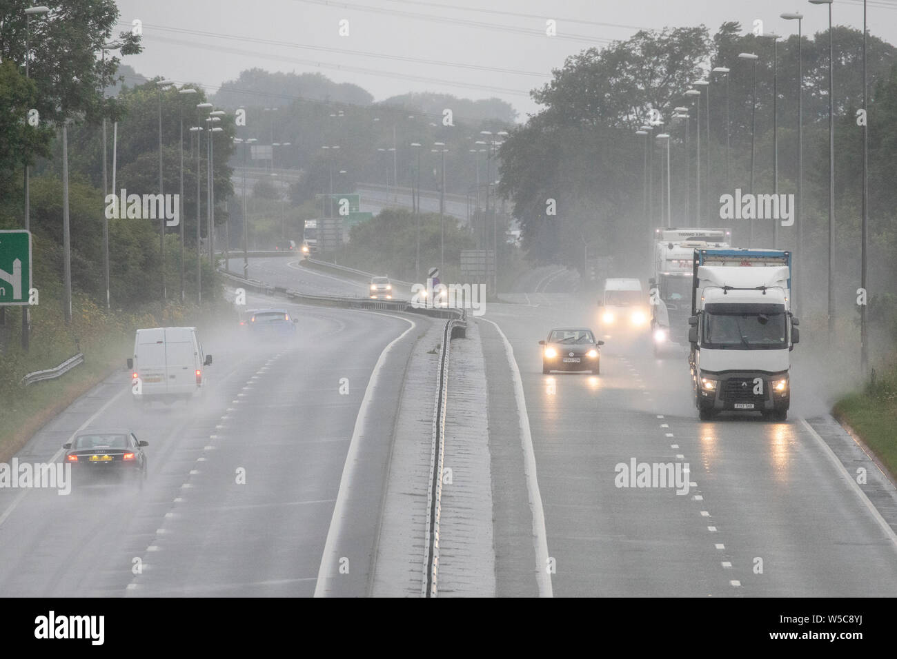 A nord-ovest, UK. Regno Unito: Meteo Domenica 28 luglio 2019. Un tempo parte anteriore si muove lentamente attraverso il paese oggi da Nord con le temperature dello scambiatore di calore e heavy rain per alcuni come esso si muove lentamente attraverso il Regno Unito come questi automobilisti scoperto su un umido A55 passando per Flintshire, il Galles del Nord © DGDImages/AlamyNews Foto Stock