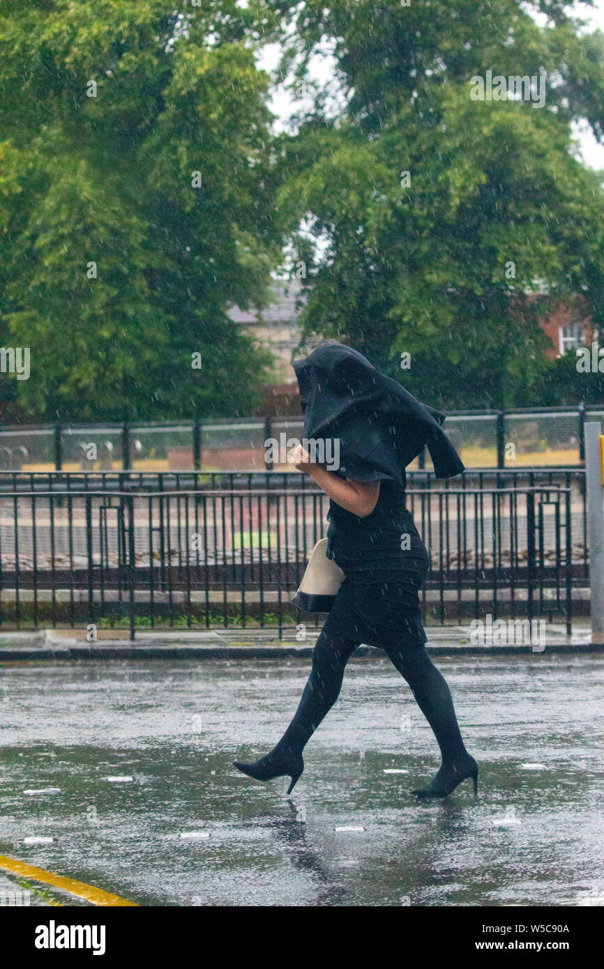 A nord-ovest, UK. Regno Unito: Meteo Domenica 28 luglio 2019. Un tempo parte anteriore si muove lentamente attraverso il paese oggi da Nord con le temperature dello scambiatore di calore e heavy rain per alcuni come esso si muove lentamente attraverso il Regno Unito come questa donna ha scoperto la stessa protezione dalla pioggia con la sua giacca nel cit di Chester, Cheshire © DGDImages/AlamyNews Foto Stock