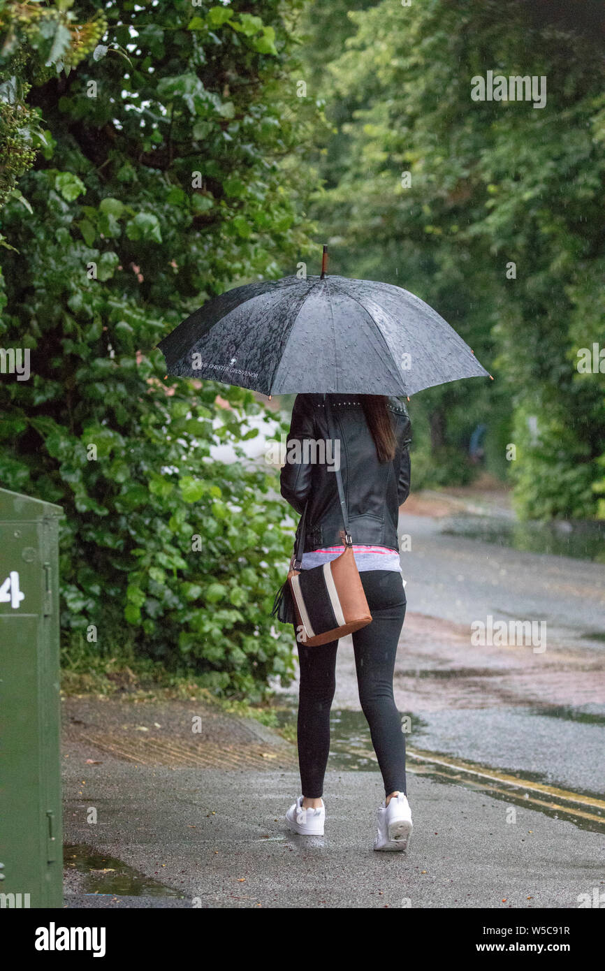 A nord-ovest, UK. Regno Unito: Meteo Domenica 28 luglio 2019. Un tempo parte anteriore si muove lentamente attraverso il paese oggi da Nord con le temperature dello scambiatore di calore e heavy rain per alcuni come esso si muove lentamente attraverso il Regno Unito come questo pedone scoperto sotto un ombrello di lei nella città di Chester, Cheshire © DGDImages/AlamyNews Foto Stock