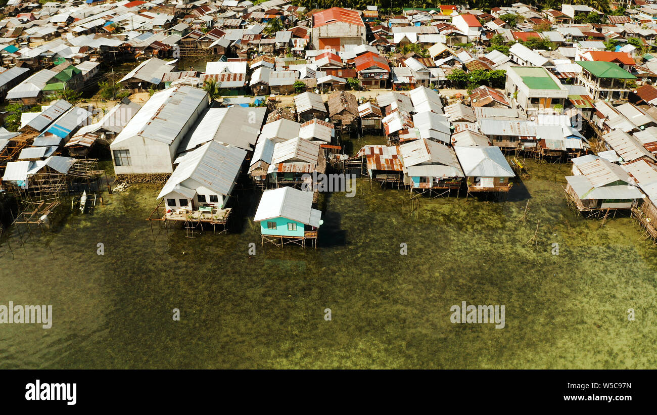 Villaggio di Pescatori con barche e baraccopoli con case in legno, antenna fuco. Il Dapa, Siargao, Filippine. Foto Stock