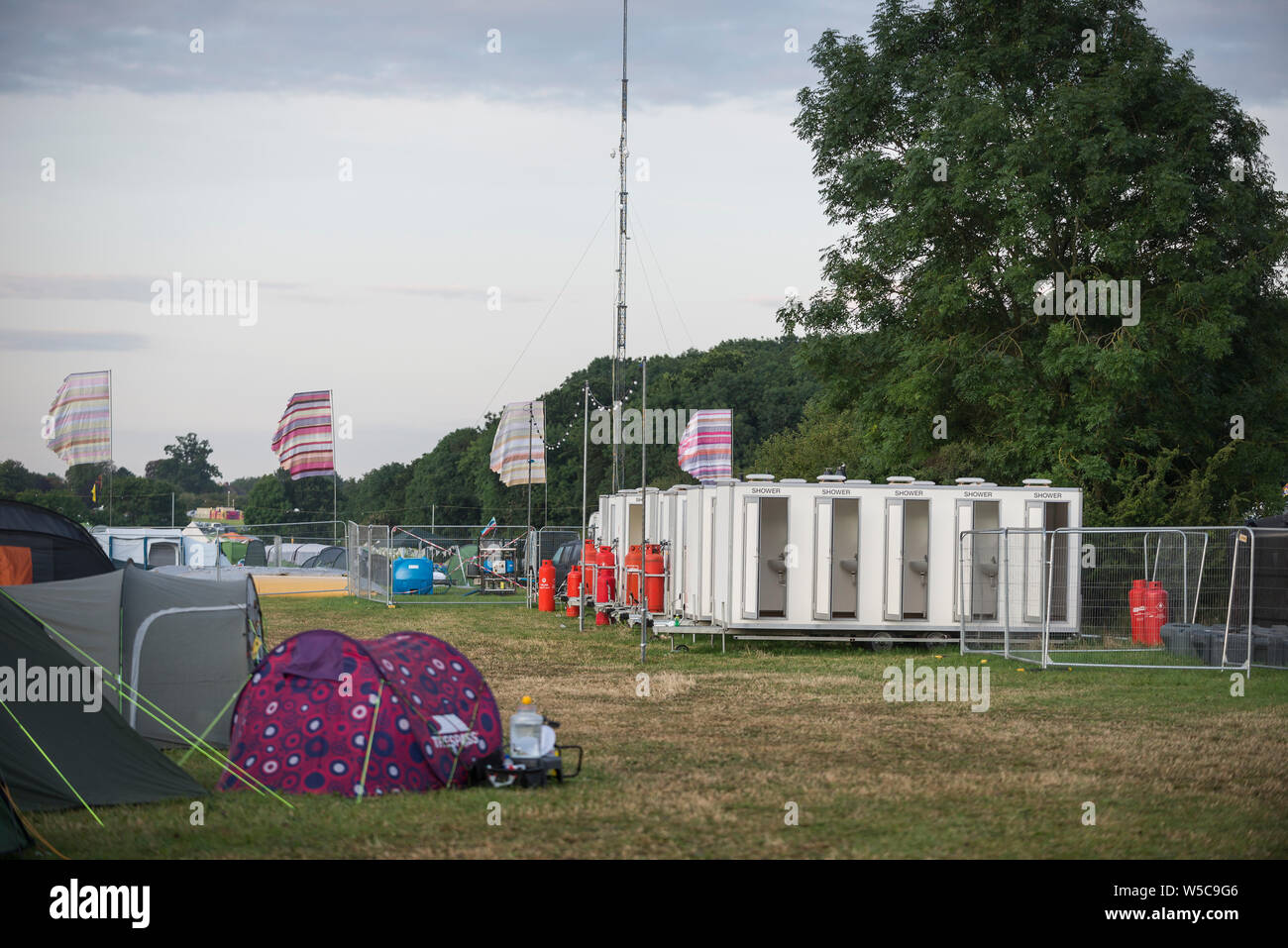 WOMAD Festival, Charlton Park, Wiltshire, Regno Unito. Il 28 luglio 2019. La domenica mattina presto scene a WOMAD, tra le 05:30-06:30, con late night festaioli stare sveglio fino alle prime ore del mattino, night-shift e della sicurezza dei lavoratori e i mattinieri che ha battuto la doccia code. Credito: Francesca Moore/Alamy Live News Foto Stock