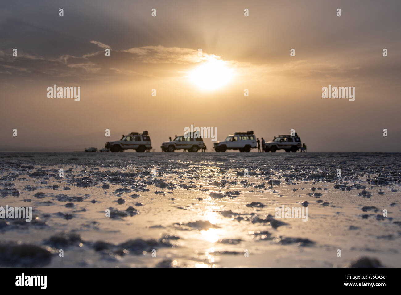 Tourist sul sale appartamenti accanto al Land Cruiser nella depressione di Danakil, Etiopia Foto Stock