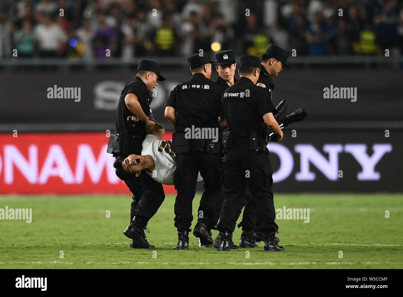 Un ventilatore adorante è azionato fuori dalla sicurezza dei membri del personale durante il 2019 International Champions Cup torneo di calcio tra Juventus F.C. e Inter nella città di Nanjing East cinese della provincia di Jiangsu, 24 luglio 2019. Foto Stock