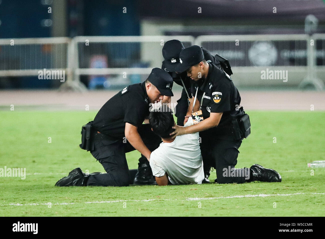 Un ventilatore adorante è azionato fuori dalla sicurezza dei membri del personale durante il 2019 International Champions Cup torneo di calcio tra Juventus F.C. e Inter nella città di Nanjing East cinese della provincia di Jiangsu, 24 luglio 2019. Foto Stock