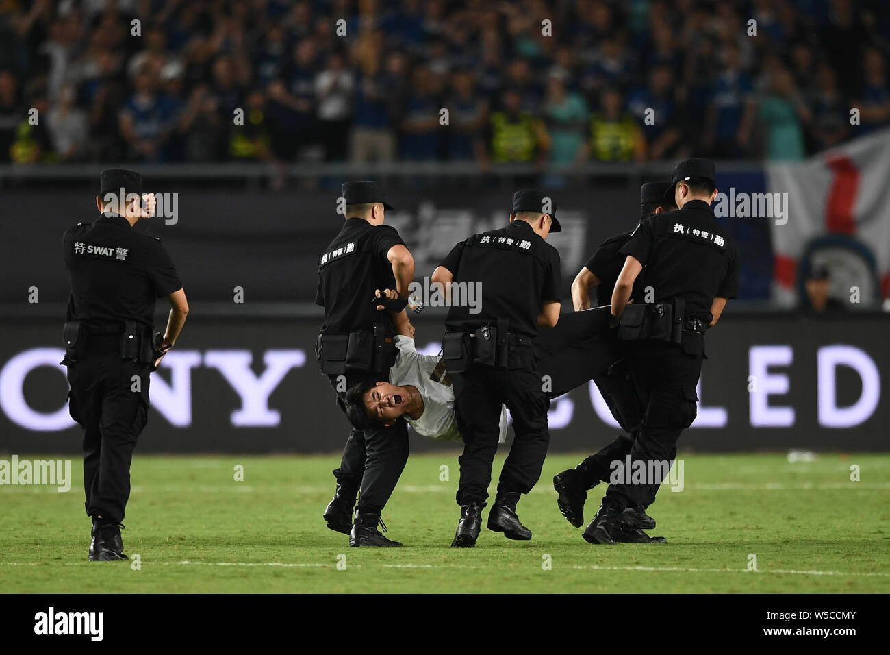 Un ventilatore adorante è azionato fuori dalla sicurezza dei membri del personale durante il 2019 International Champions Cup torneo di calcio tra Juventus F.C. e Inter nella città di Nanjing East cinese della provincia di Jiangsu, 24 luglio 2019. Foto Stock