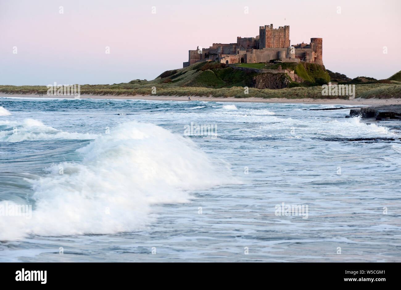 Il castello di Bamburgh e mare mosso in Northumberland Gran Bretagna Foto Stock