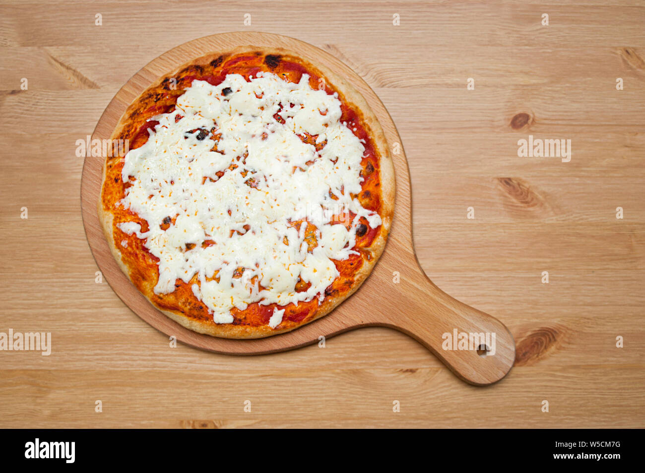 Pizza calda a destra fuori del forno su una tavola di legno che serve la piastra Foto Stock