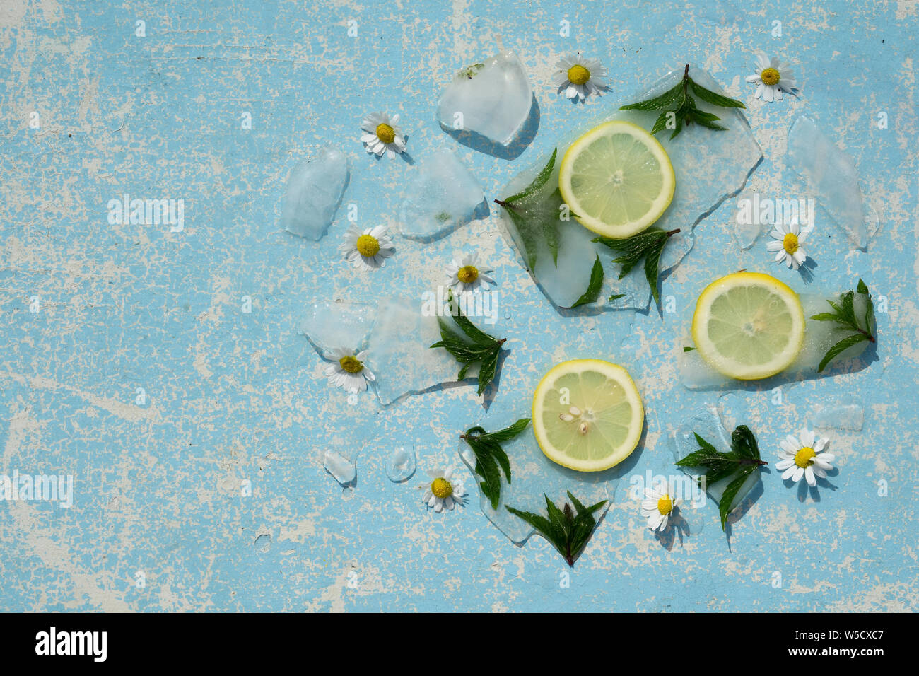 Sfondo verde delle foglie di menta e di limone in cubetti di ghiaccio con bolle di aria Foto Stock