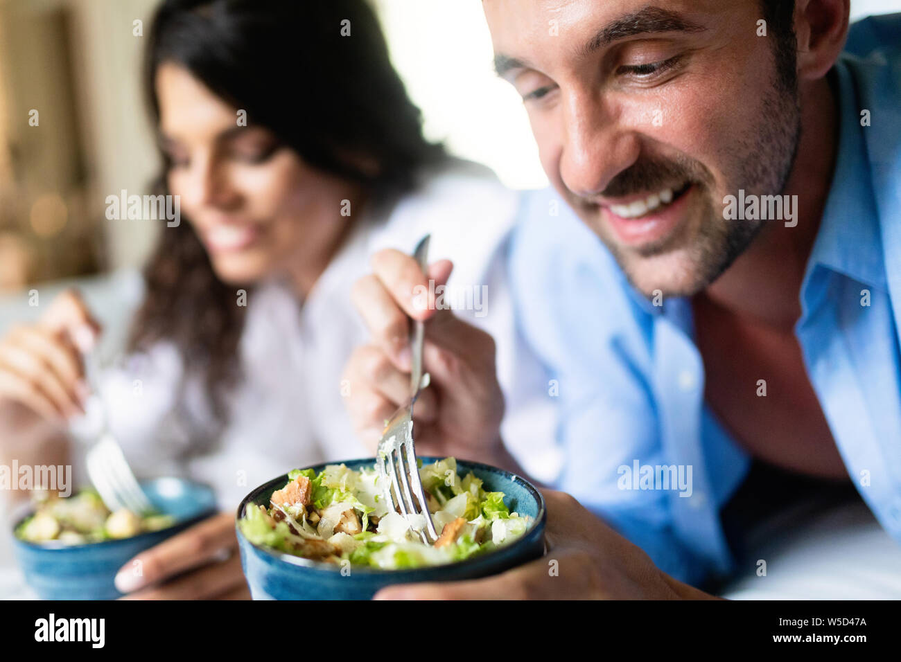 Allegro coppia giovane avente la colazione a letto Foto Stock