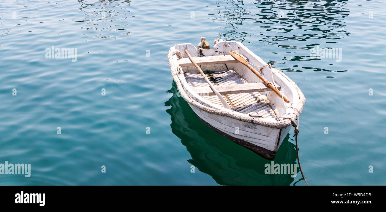 Bianco barca in legno su blu acqua calma nel lago Foto Stock