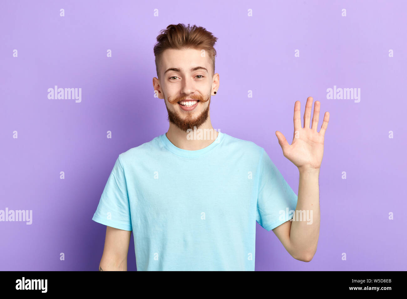 Positivo uomo allegro che mostra il suo aprire palm emozioni umane, le espressioni del viso uomo bello agitando la mano, ciao, ciao, buona sera, vedere di seguito. Foto Stock