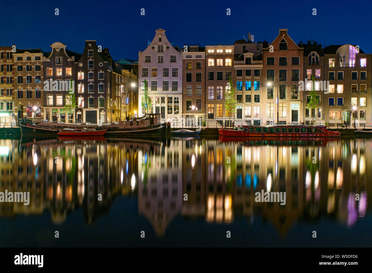 La riflessione degli edifici lungo il canale di notte a Amsterdam, Paesi Bassi Foto Stock