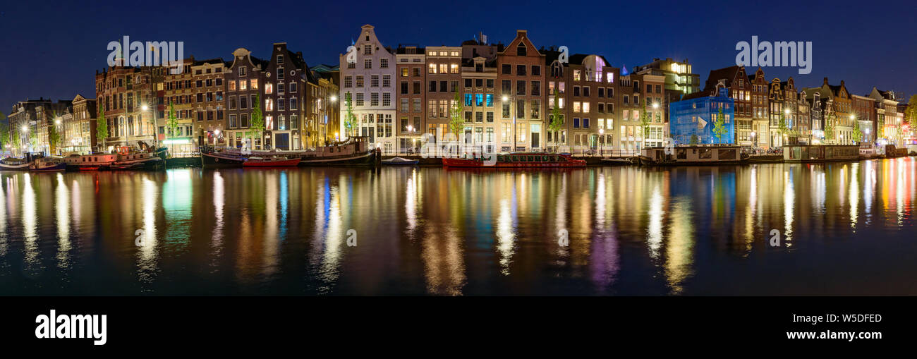 Panorama della riflessione di edifici lungo il canale di notte a Amsterdam, Paesi Bassi Foto Stock