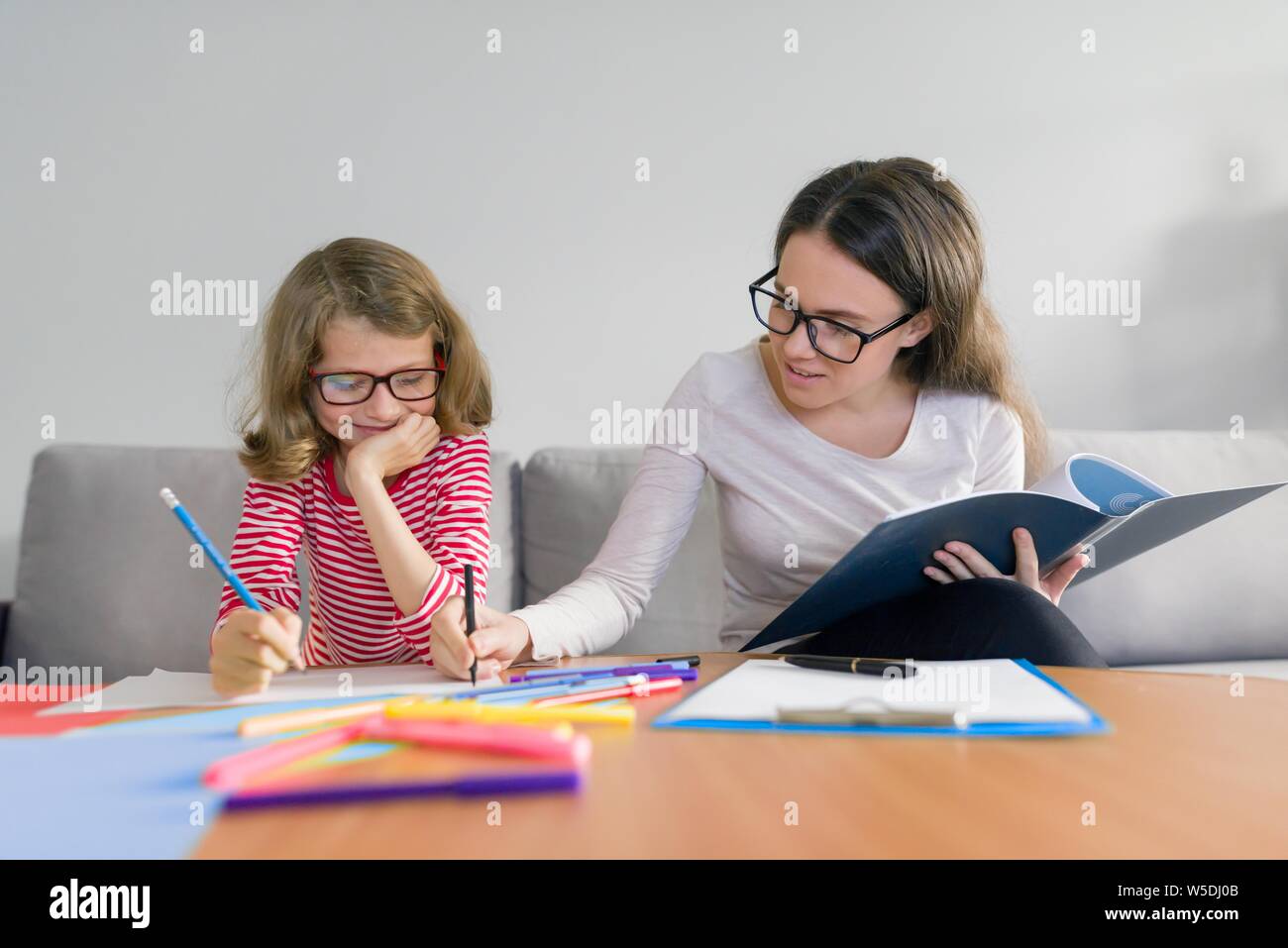 Giovane donna maestra insegna la scuola primaria ragazza. I singoli privati lezioni di educazione a casa Foto Stock