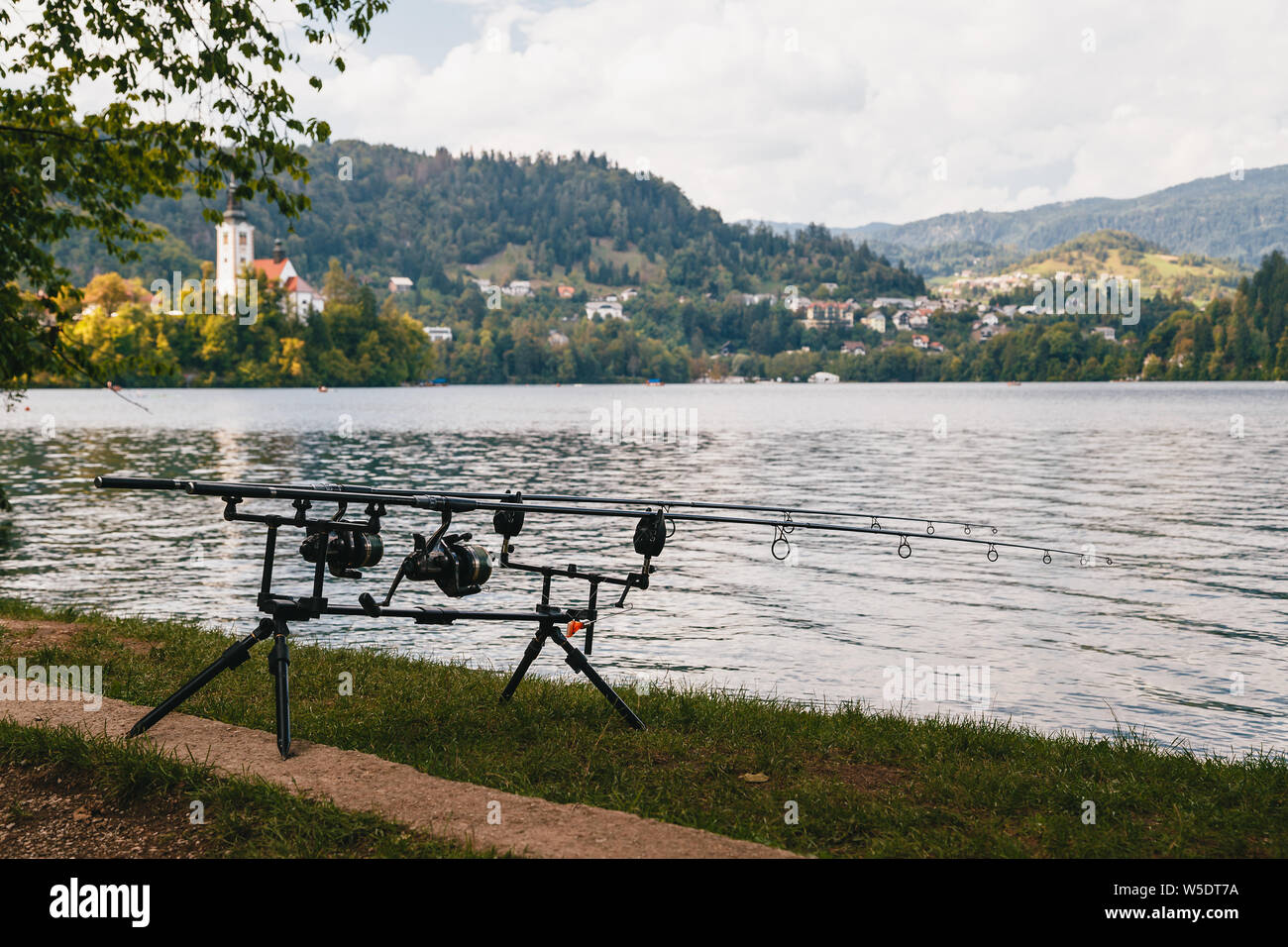 La pesca sul lago di Bled, Slovenia. Due moderne canne da pesca sulla banca del lago Foto Stock