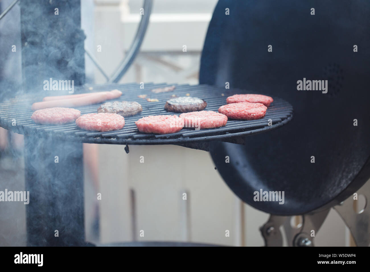 Preparazione di hamburger di succose bistecche alla griglia Foto Stock