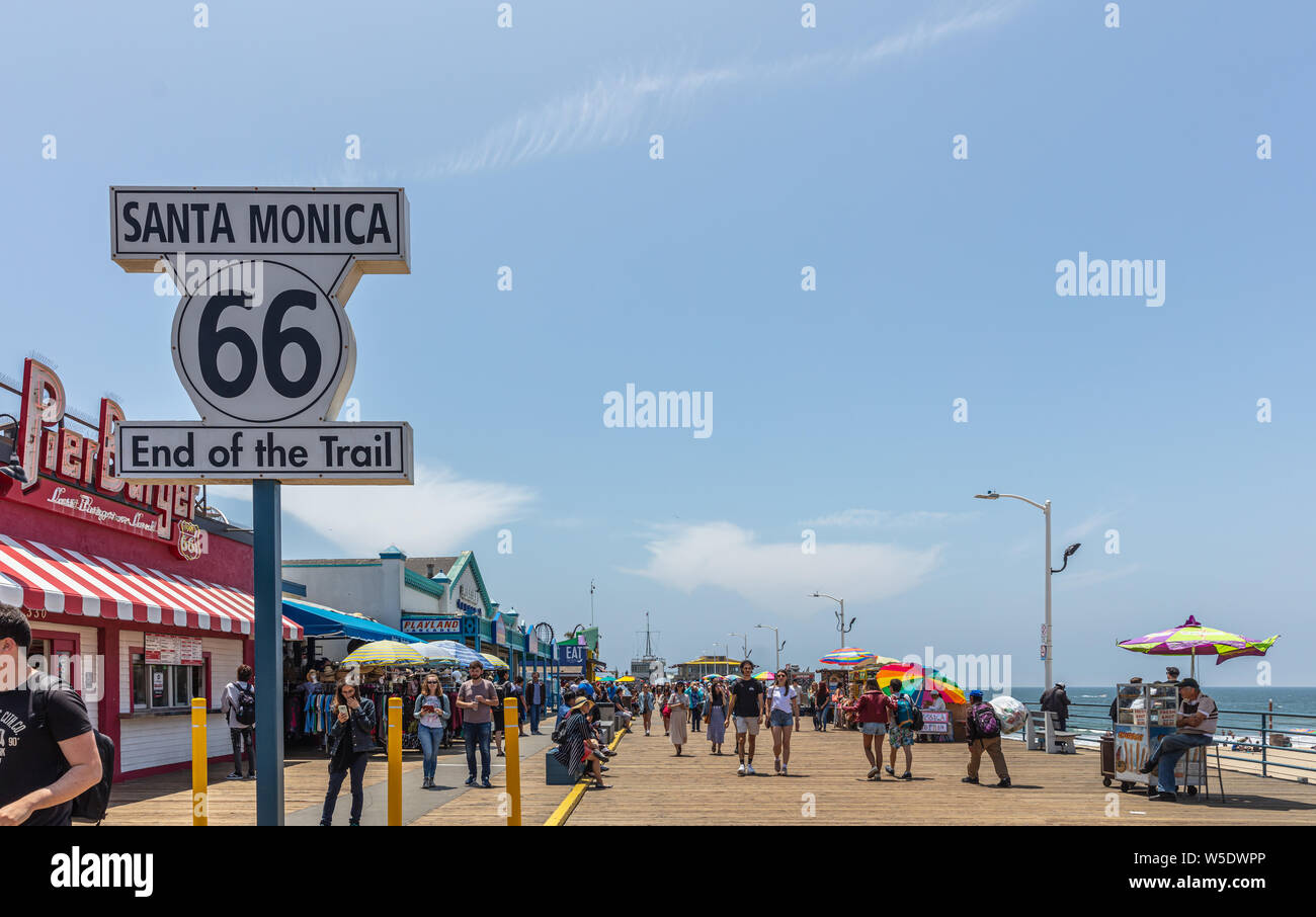 Los Angeles California USA. Maggio 30, 2019. Santa Monica Pier e Route 66 Fine del sentiero, colore bianco segno. La gente camminare al molo, cielo blu backgro Foto Stock