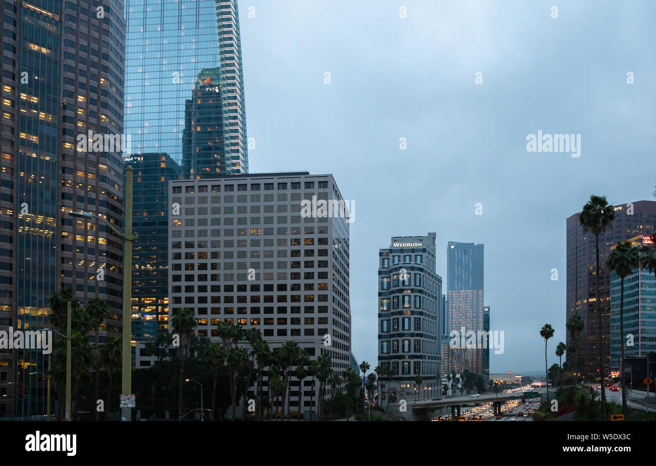 Los Angeles California USA. Il 1 giugno 2019. Grattacieli illuminati, luci auto in strada il cielo blu di sfondo, serata primaverile Foto Stock