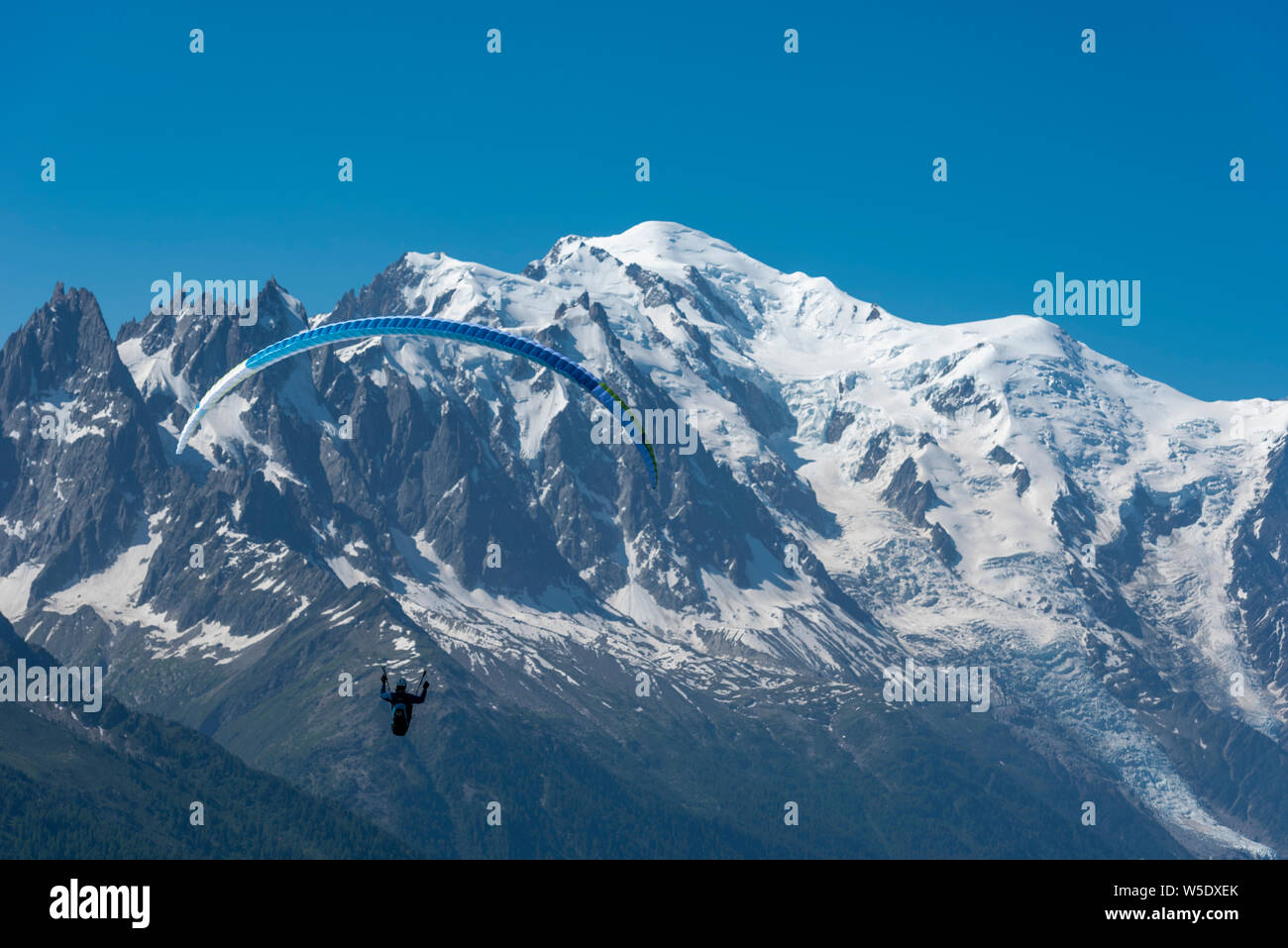 Parapendio volare al di sopra della valle di Chamonix con spettacolari vedute sul Mont Blanc gamma, Chamonix Haute Savoie, Francia Foto Stock