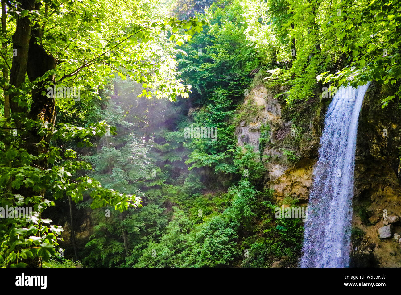 La magica atmosfera di una cascata nel verde delle foreste in una giornata di sole Foto Stock