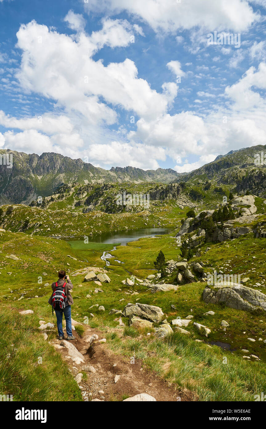 Escursionista presso Estanh des Gargolhes de Baish lago di Aigüestortes i Estany de Sant Maurici National Park (Valle de Arán, Lleida, Pirenei, Catalogna, Spagna) Foto Stock