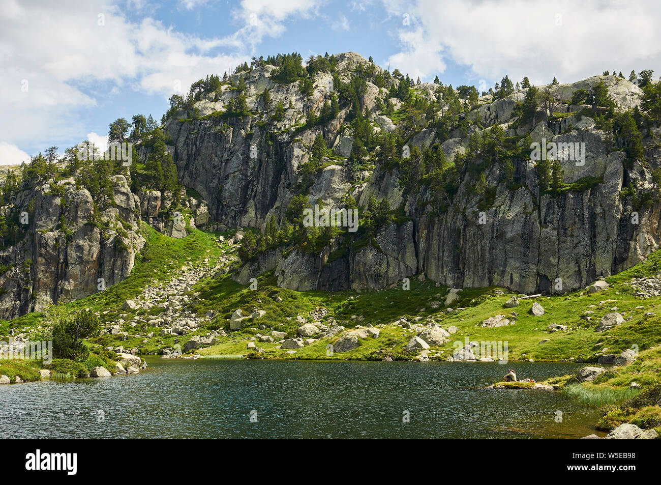 Gli escursionisti in appoggio al piano Estanh lago di Aigüestortes i Estany de Sant Maurici National Park (Valle de Arán, Lleida, Pirenei, Catalogna, Spagna) Foto Stock