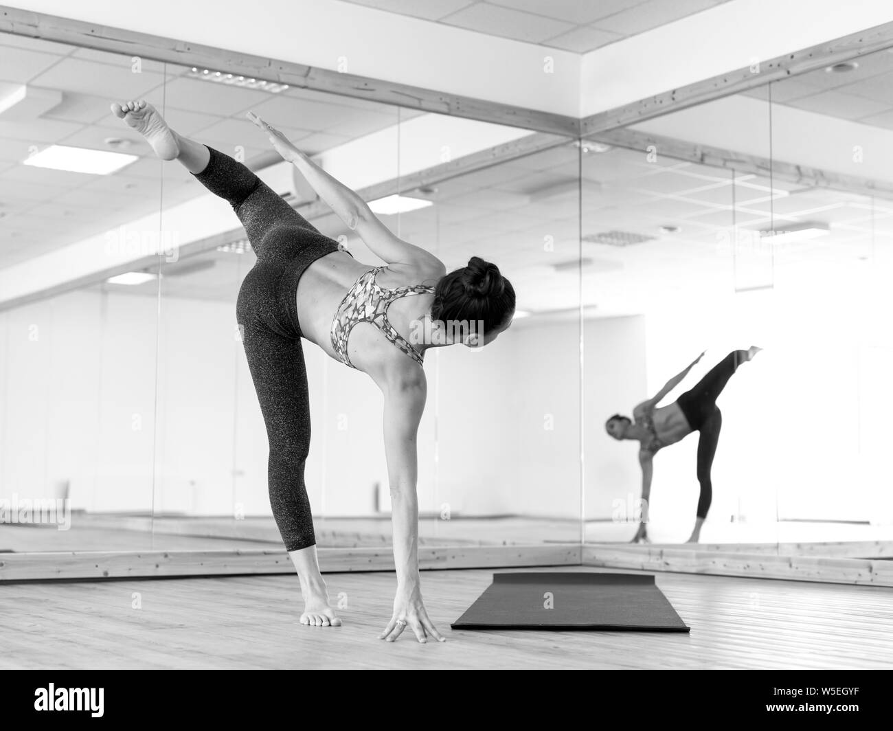 Montare sportivo ragazza attiva in sportswear fare yoga fitness in esercizio in studio di yoga. Foto Stock