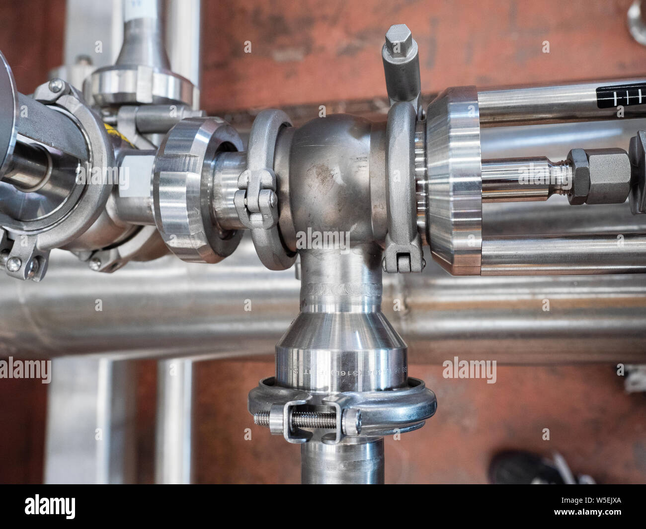 Tubi in acciaio inox con collegamenti complessi presso un impianto di trasformazione industriale. Foto Stock