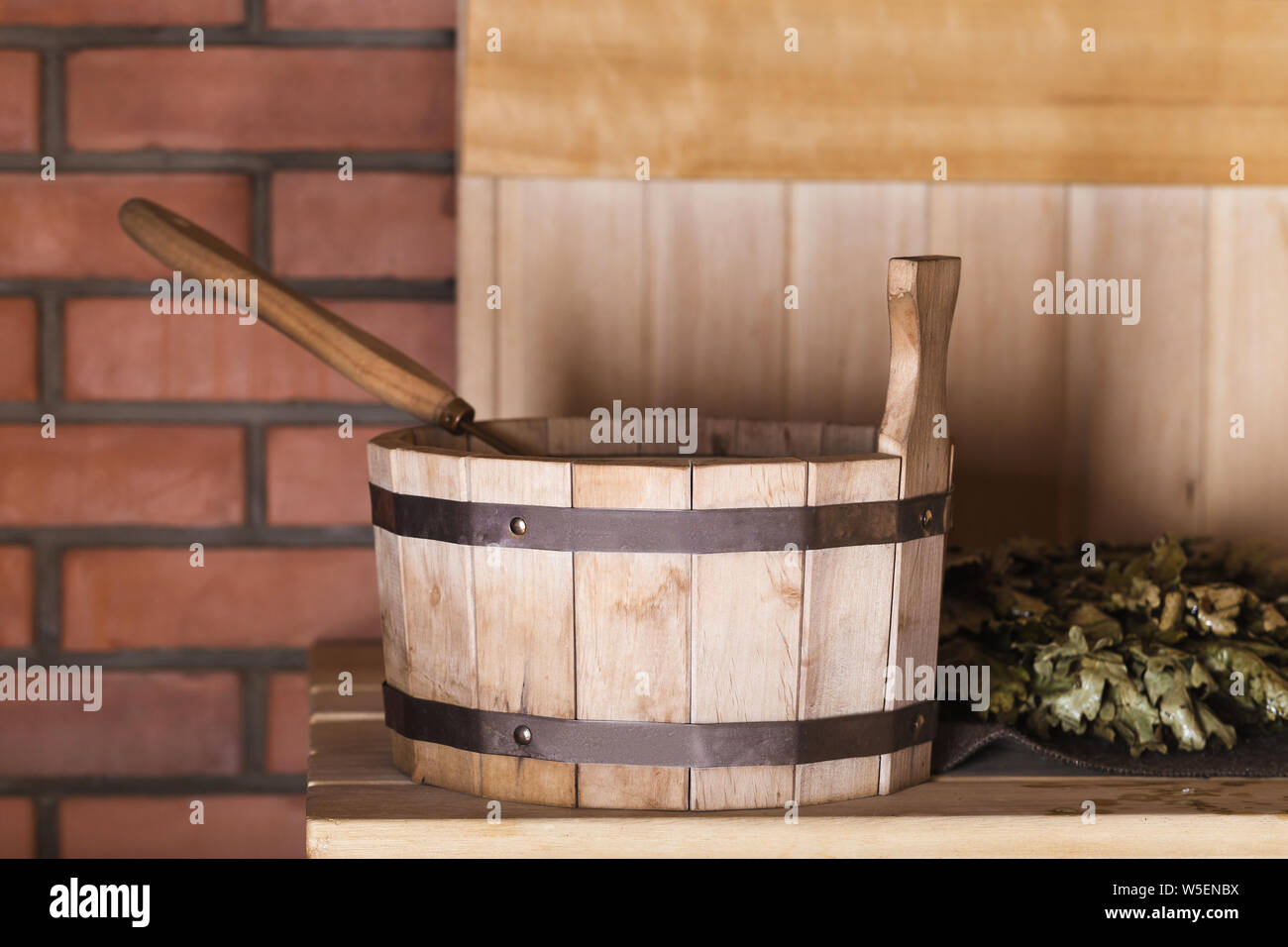 Cucchiaio di legno con un mestolo e una scopa nella sauna Foto Stock