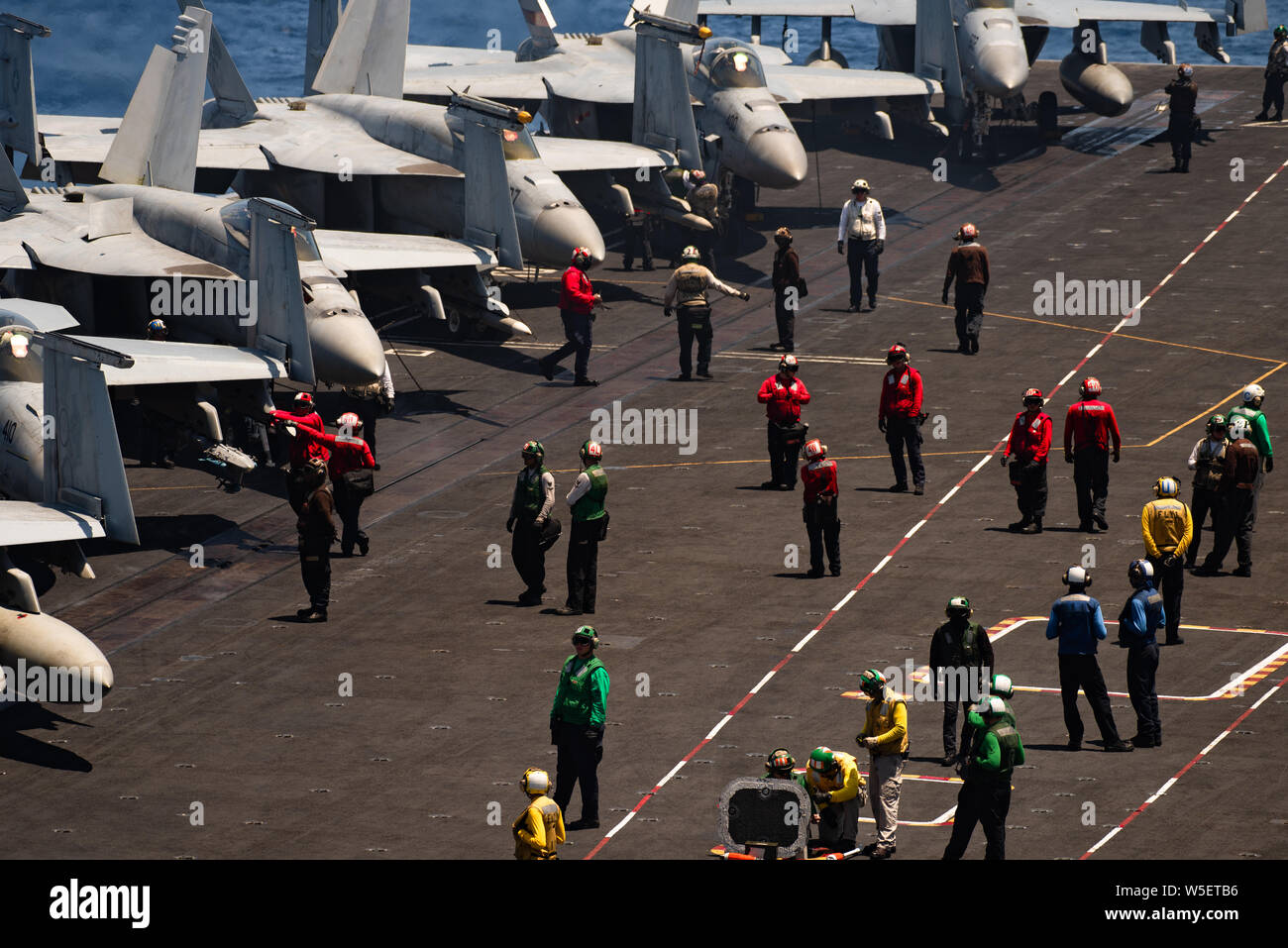 190724-N-ZM949-2108 OCEANO PACIFICO (24 luglio 2019) il transito dei marinai il ponte di volo della portaerei USS Theodore Roosevelt CVN (71) prima di iniziare le operazioni di volo. Theodore Roosevelt sta conducendo le operazioni di routine nell'Oceano Pacifico orientale. (U.S. Foto di Marina di Massa lo specialista di comunicazione di terza classe Erick A. Parsons/rilasciato) Foto Stock