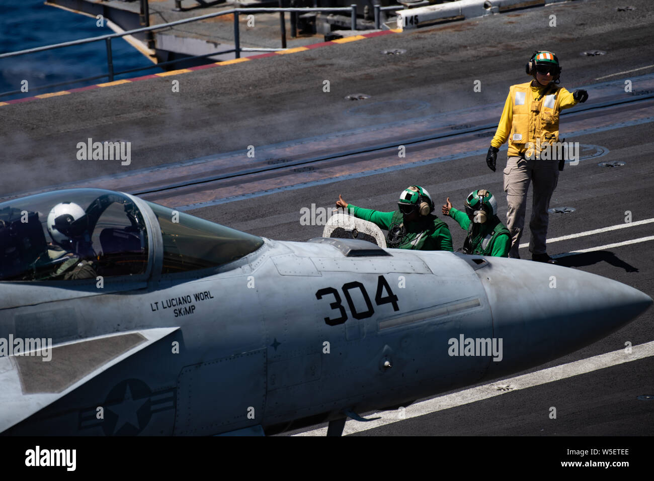 190724-N-ZM949-2070 OCEANO PACIFICO (24 luglio 2019) marinai dare il segnale per il lancio di un'F/A- 18E Super Hornet, assegnato su "i diamanti blu" di Strike Fighter Squadron (VFA) 146, sul ponte di volo della portaerei USS Theodore Roosevelt CVN (71). Theodore Roosevelt sta conducendo le operazioni di routine nell'Oceano Pacifico orientale. (U.S. Foto di Marina di Massa lo specialista di comunicazione di terza classe Erick A. Parsons/rilasciato) Foto Stock