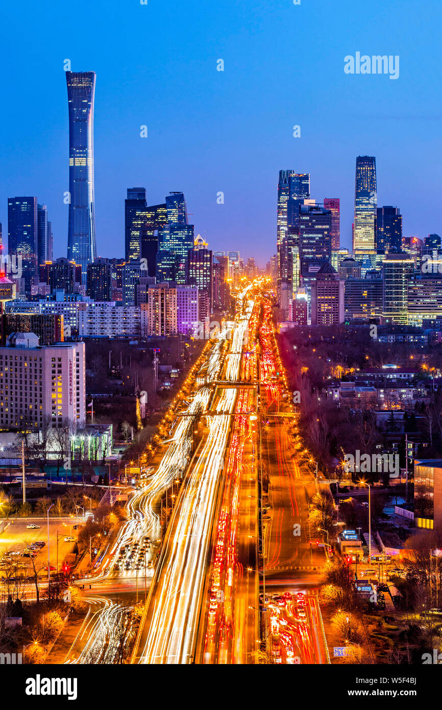 Una vista notturna delle strade trafficate con le masse dei veicoli di fronte al CITIC Tower e altri grattacieli in CBD (Central Business District) in bei Foto Stock