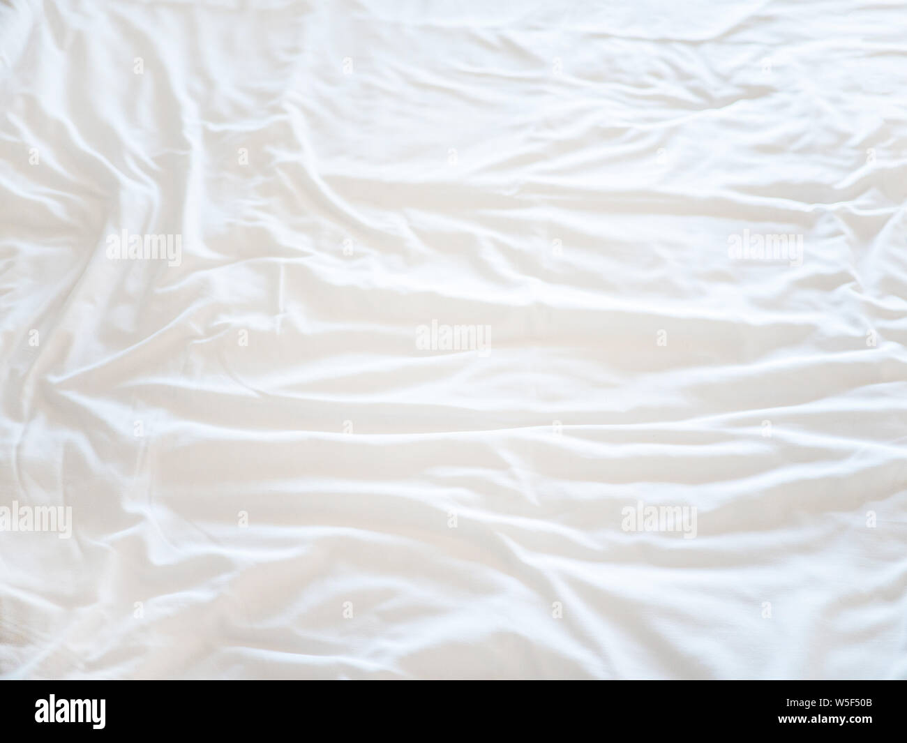 Vista dall'alto di lenzuola piega, bianco tessuto rugosa di tessitura per la massa posteriore Foto Stock