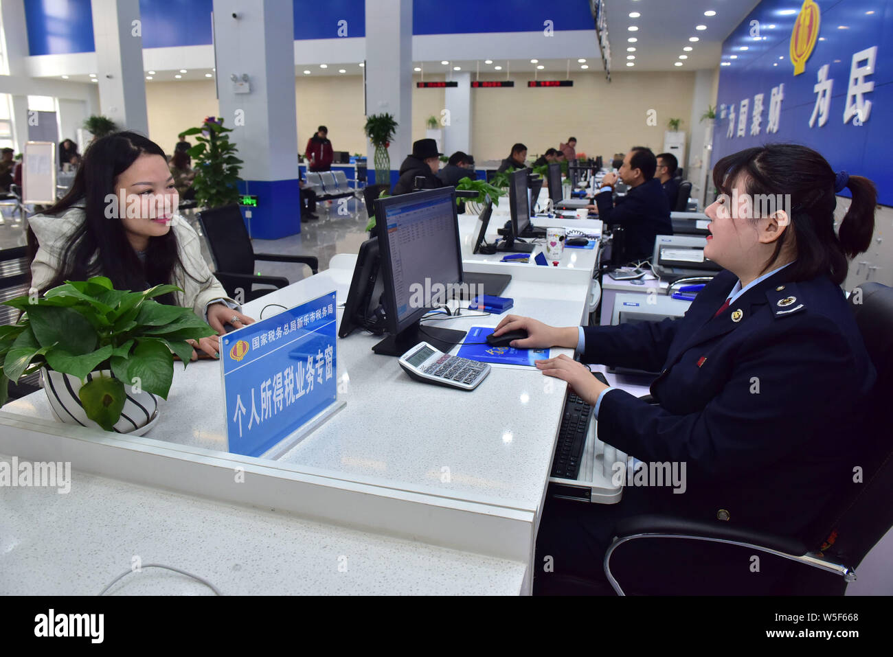 --FILE -- un membro del personale dell'Ufficio fiscale di Xinle introduce la nuova politica dei singoli redditi (IIT) ai cittadini in città Xinle, centrale della Cina di Eb Foto Stock