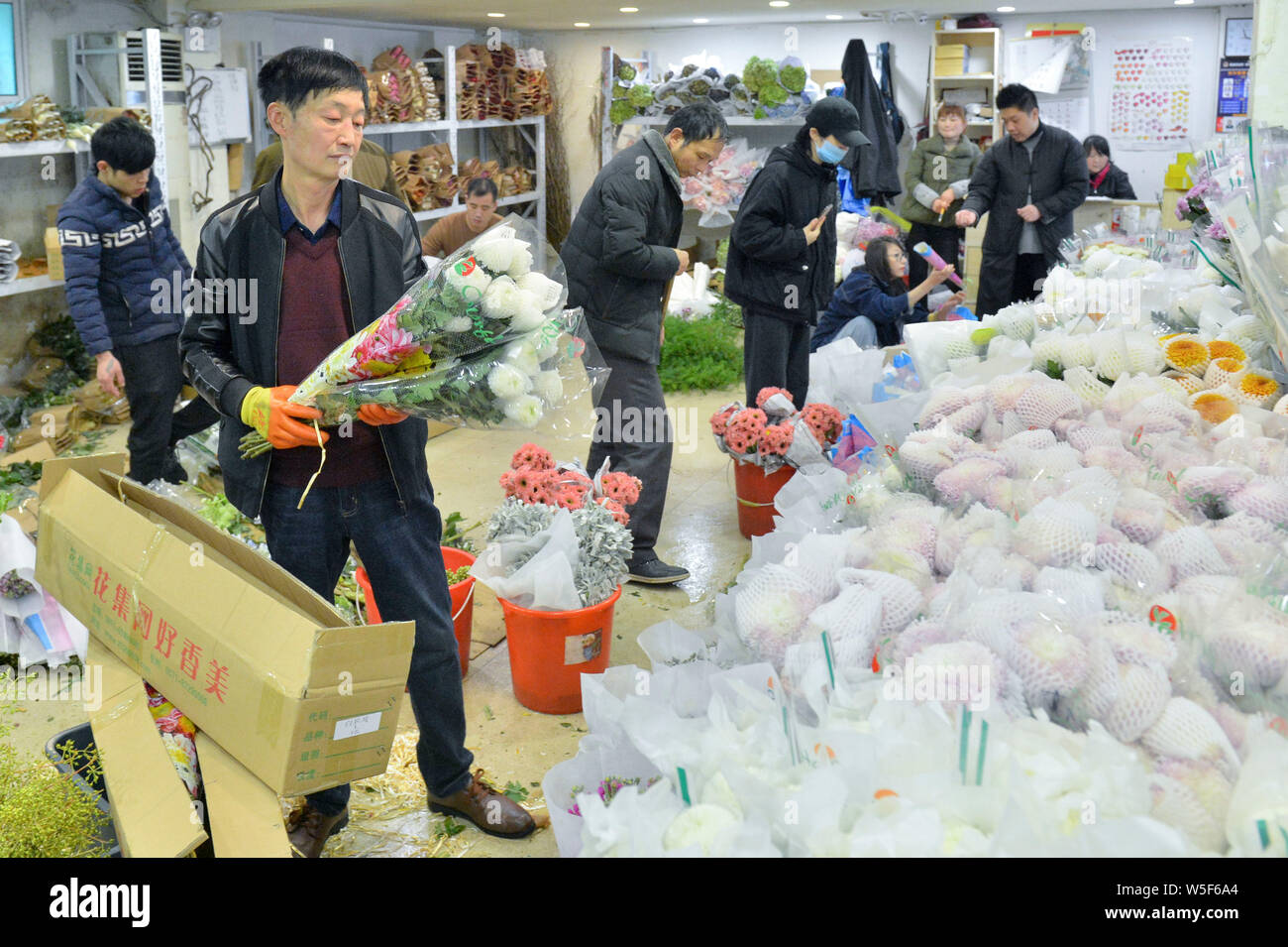 Dipendenti cinesi fiori display a un mercato dei fiori in anticipo del lavoro internazionale la Giornata della donna in Hangzhou, est della Cina di provincia dello Zhejiang, Foto Stock