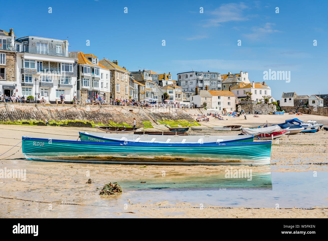 Una bella giornata di primavera al mare di St Ives in Cornovaglia, la foto è nel porto di due corse ormeggiate barche gig insieme contro la banchina. Foto Stock