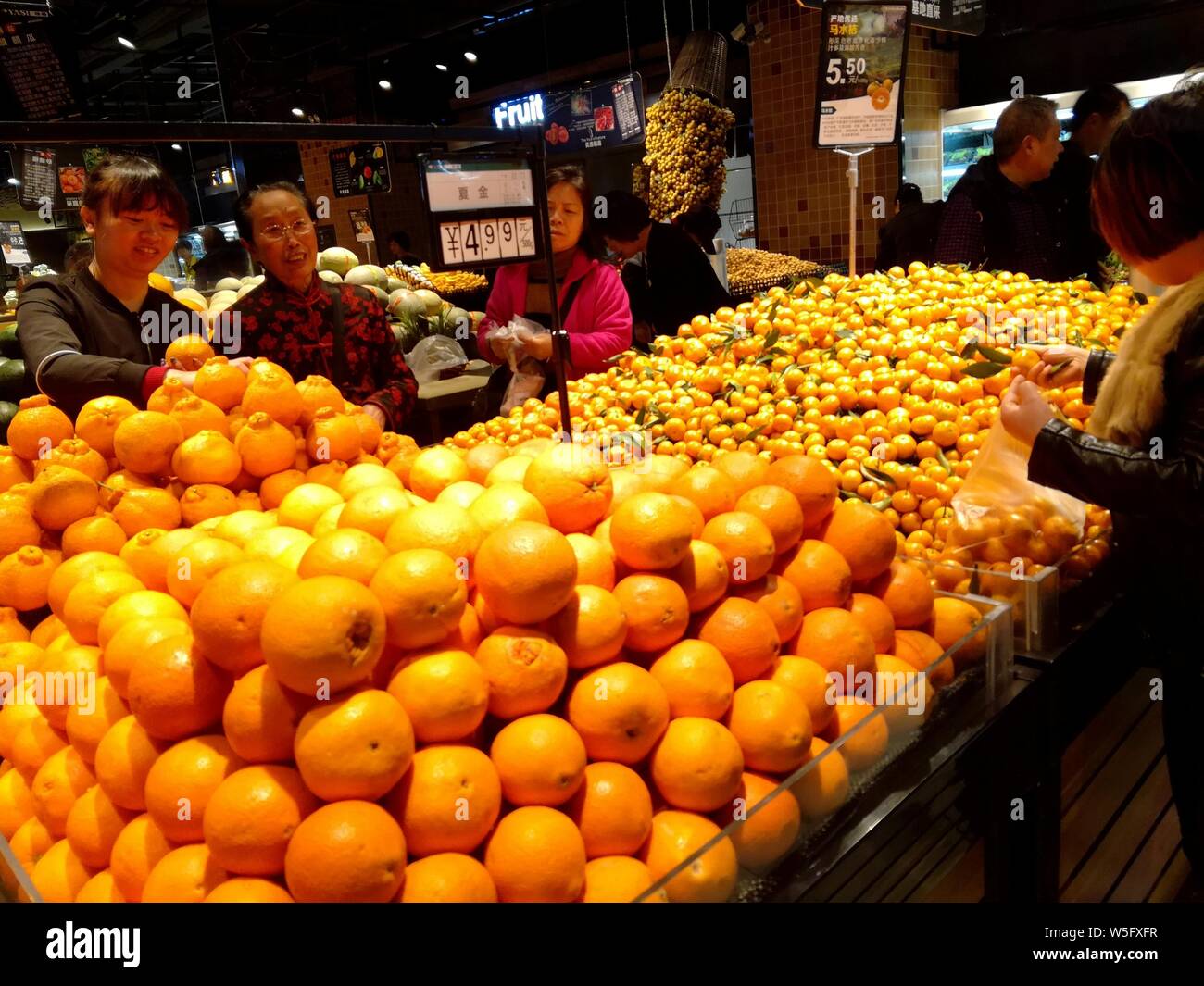 Un cliente negozi di frutta in un supermercato a Yichang city, centrale cinese della provincia di Hubei, 14 marzo 2019. Della Cina di vendite al dettaglio di beni di consumo Foto Stock