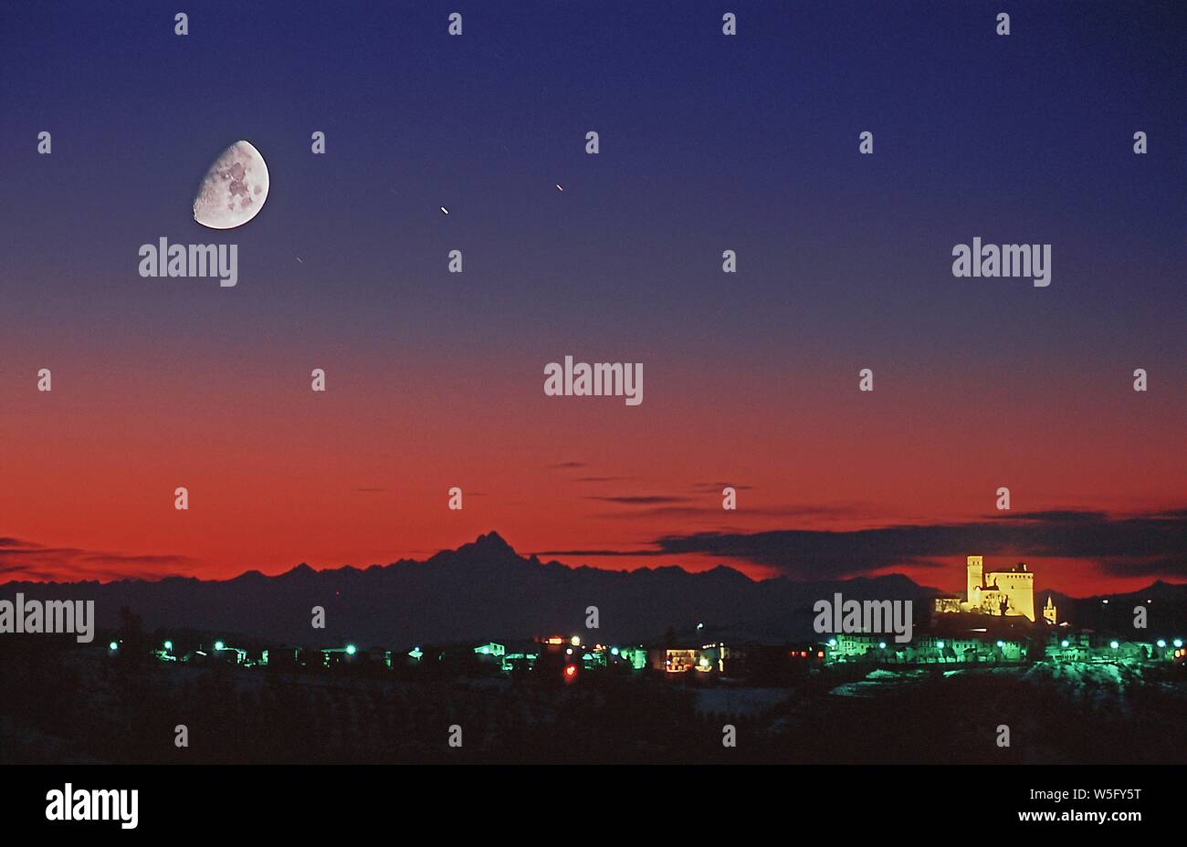 L'Italia, Piemonte, Langhe, Serralunga d'alba al tramonto con la luna e le stelle di percorsi - sullo sfondo il Monte Monviso Foto © Roberto Sacco/Sintesi/Alamy Foto Stock