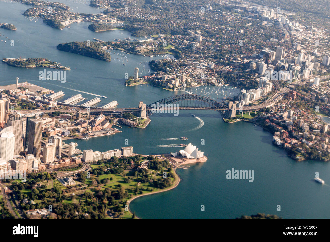 Vista aerea di Sydney di punti di riferimento: North Shore, Circular Quay, Harbour Bridge, Opera House e immediatamente al di sotto, il Giardino Botanico di Sydney, Nuovo S Foto Stock